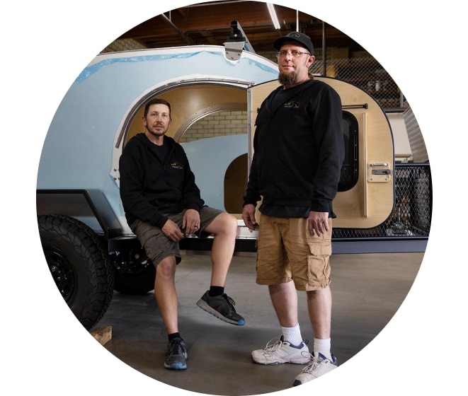 SoCal Teardrops business owners stand in front of a trailer.