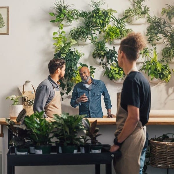 Employer talking to employees in a garden shop.