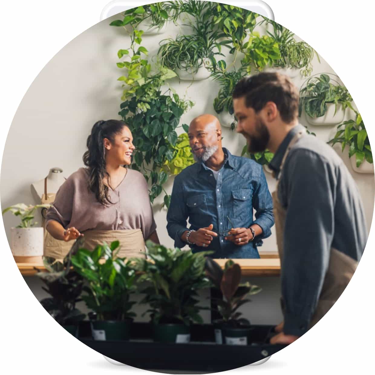 Employees and business owner conversing in a garden shop.