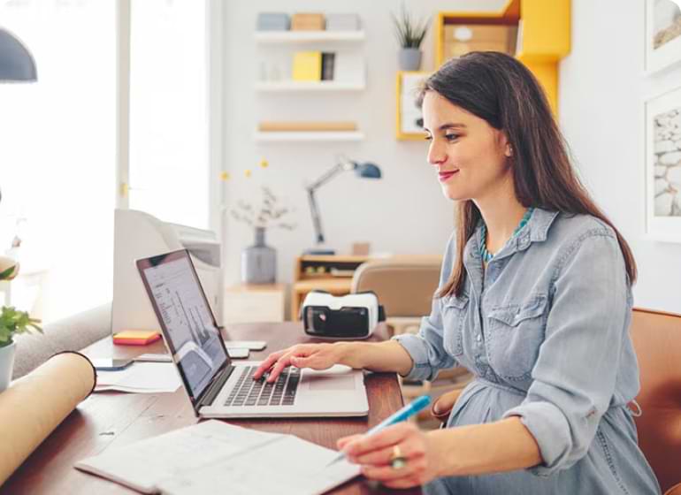 A bookkeeper sitting at a desk in front of a laptop computer.