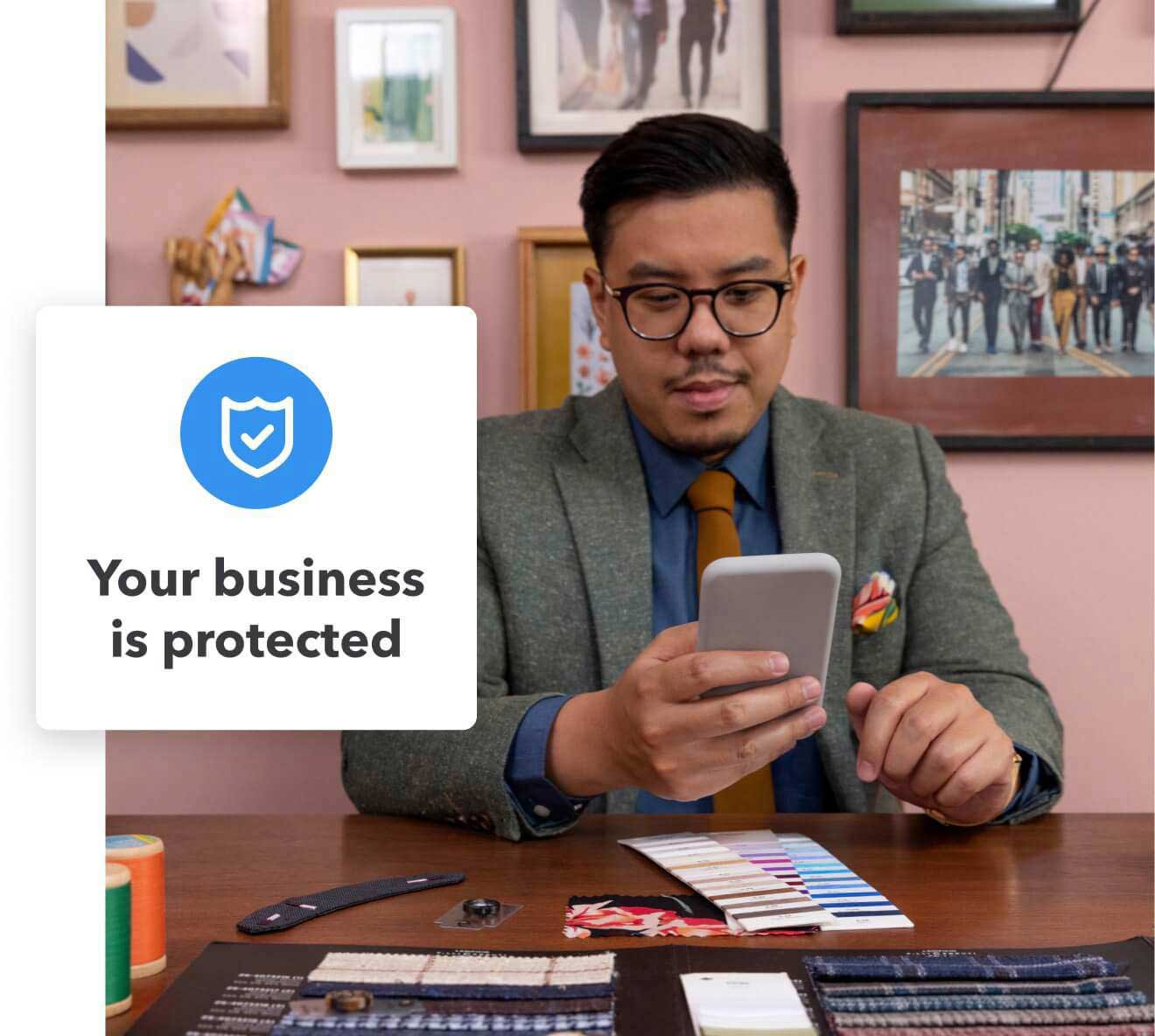 Business owner looking at email on his phone that says 'Your business is protected'
