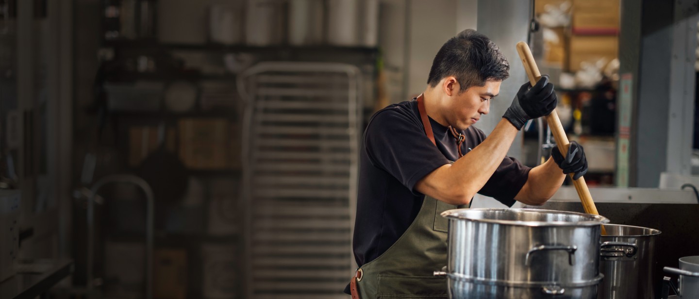 A business owner preps the kitchen for the next batch of bottled foods.