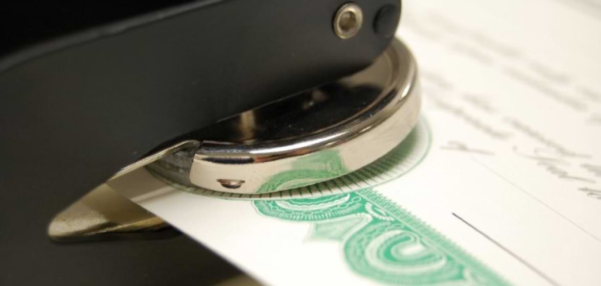 A metal seal stamping a certificate.