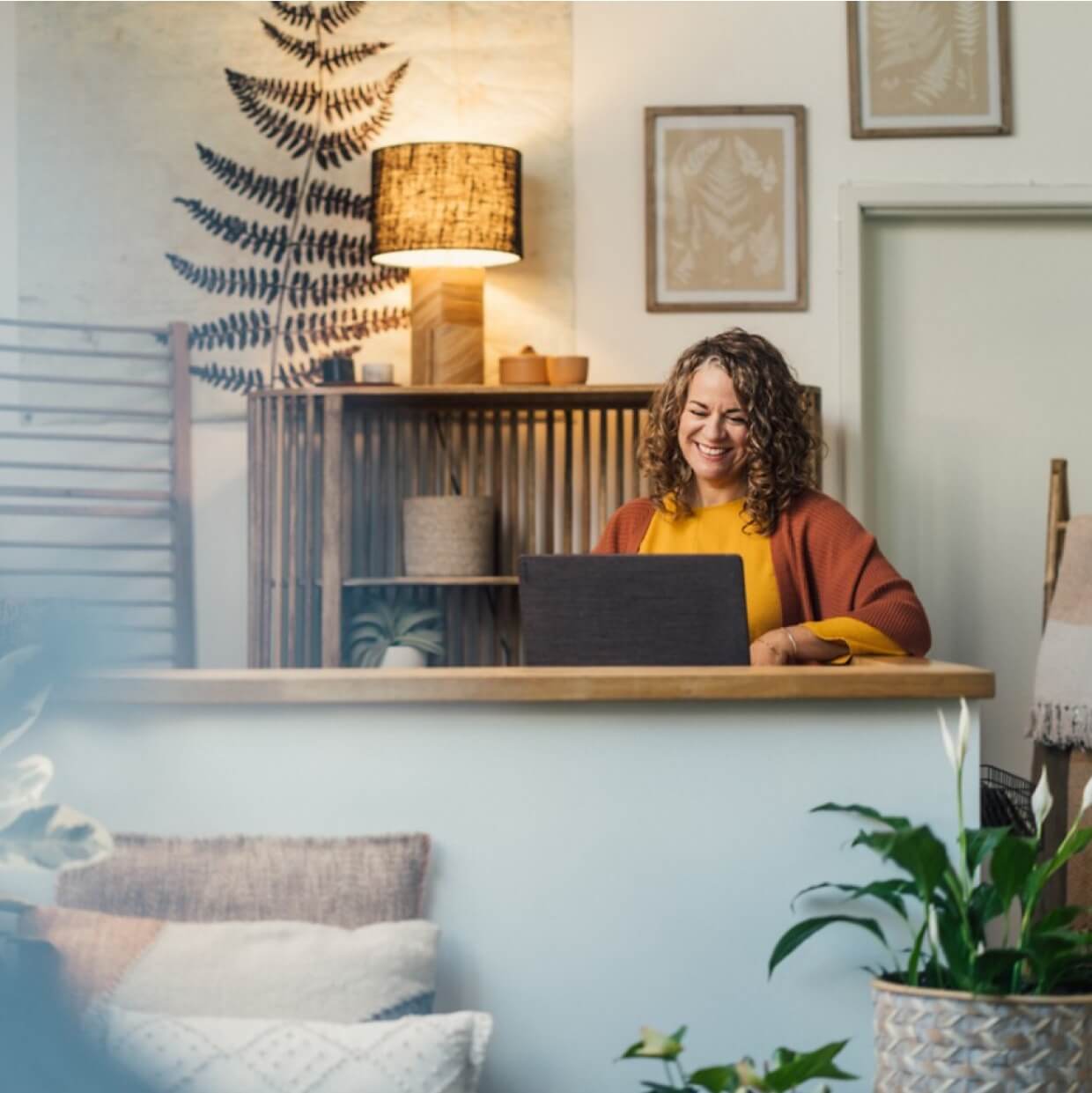 A business owner is sitting at a desk reviewing bookkeeping data on a laptop.