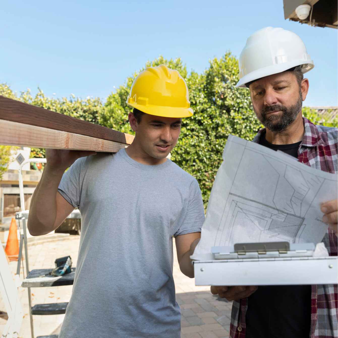 Construction business owner showing blueprints to an employee