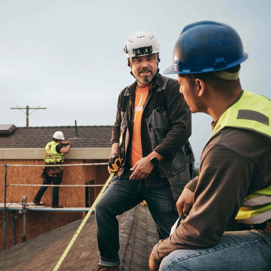 Construction workers talking on the roof.