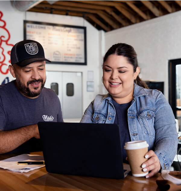 Coworkers working on computer in barbecue restaurant