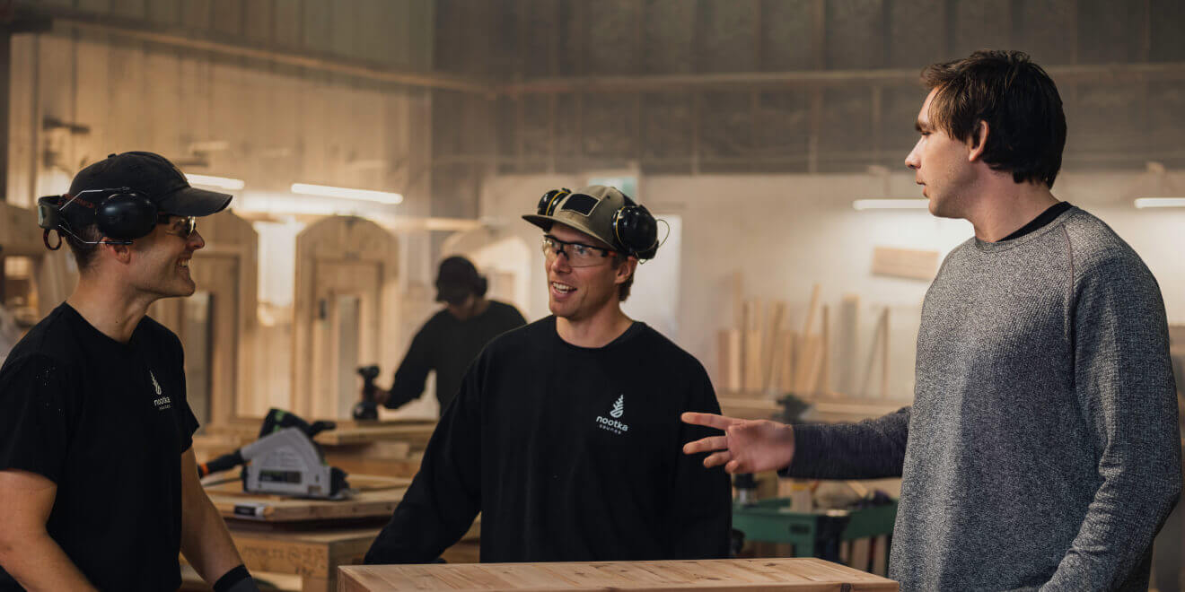 Three persons having a conversation in a workshop