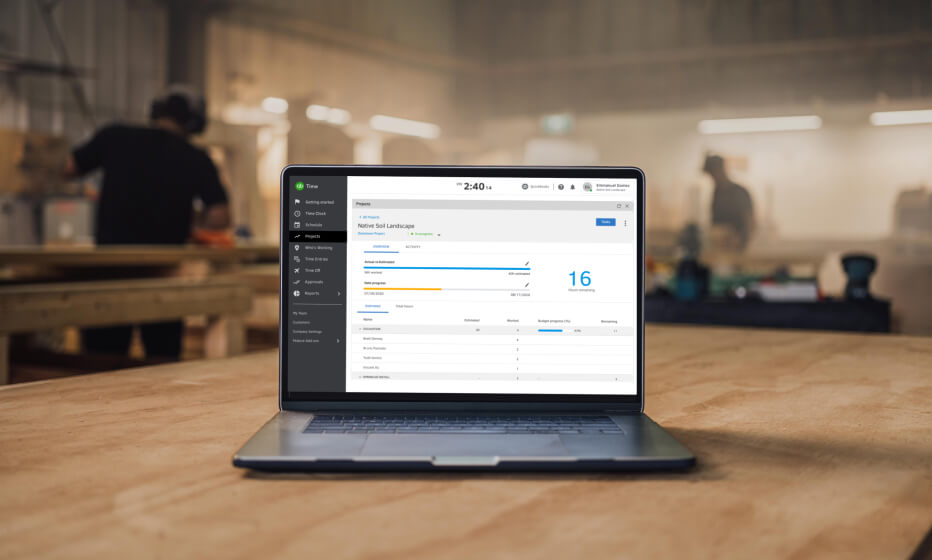 Laptop on a workshop table and a snapshot of hours worked.