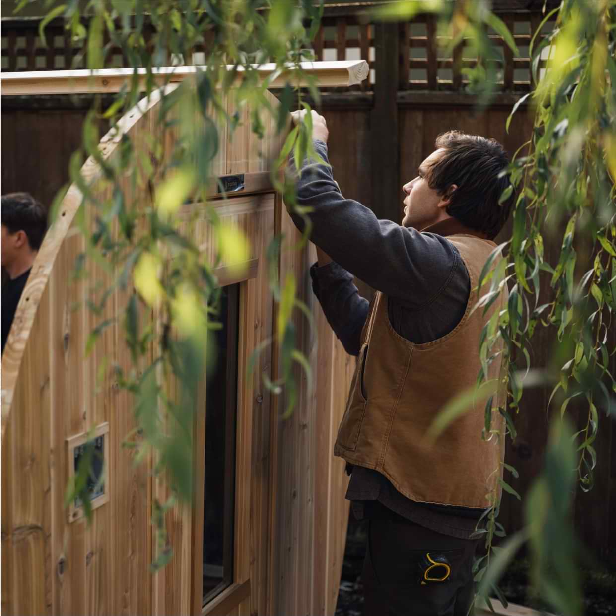 Business owner working on building a sauna in the yard.