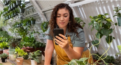 Woman looking at phone in plant shop