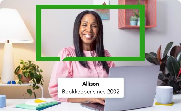 A QuickBooks bookkeeper named Allison is sitting at a desk and smiling. 