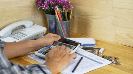 A self-employed person using a calculator to calculate business expenses