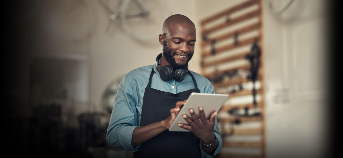 A person holding a cup of coffee and a laptop.