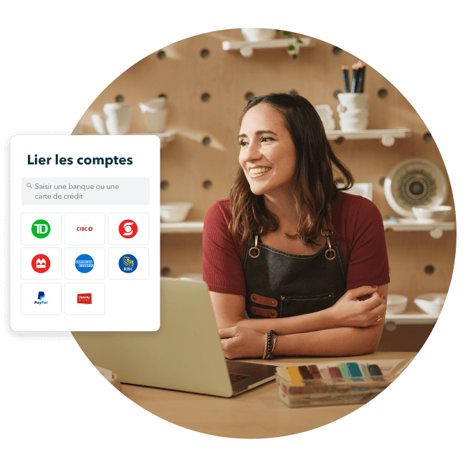 Une propriétaire d’entreprise heureuse, assise à une table et utilisant son ordinateur portable. Une fenêtre contextuelle affiche la façon dont un compte bancaire peut être lié dans QuickBooks en ligne.