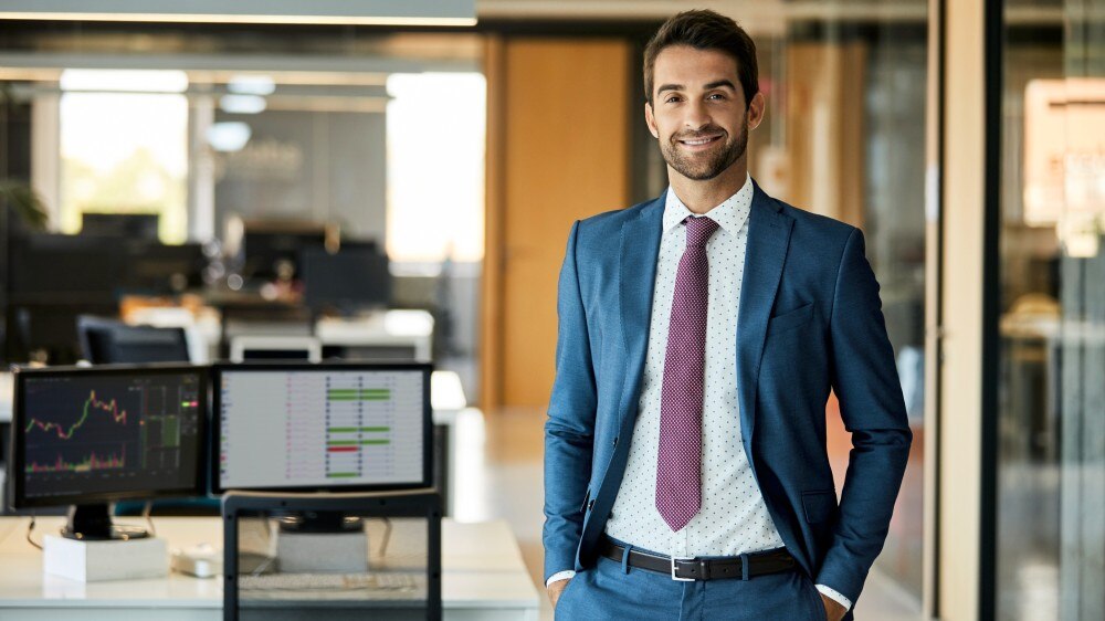 imagem de um homem de cabelo curto, usando terno azul e olhando para a câmera sorrindo em um escritório de contabilidade ilustrando artigo sobre o que é DCTF